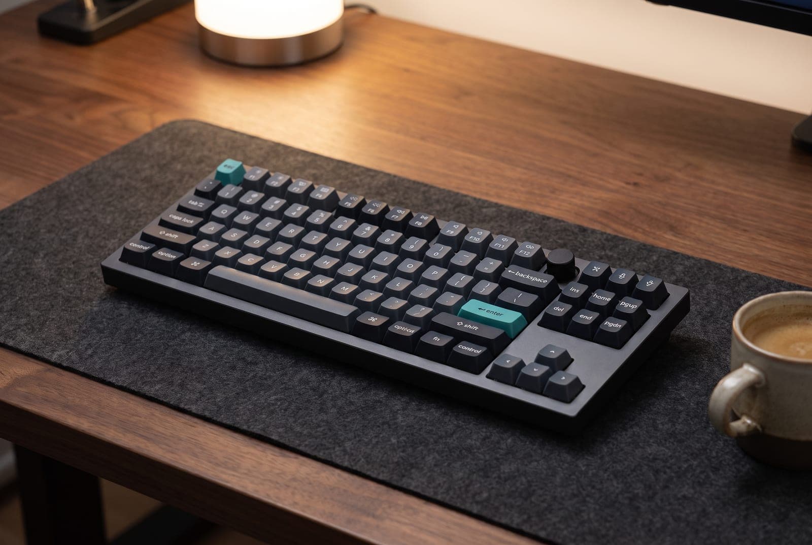Keychron Q3 Max tenkeyless keyboard with a machined aluminum case and control knob on a walnut desk, its dark PBT keycaps lit warmly