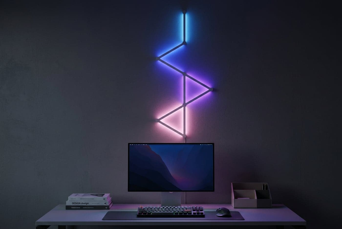 Nanoleaf Lines light bars mounted in a connected geometric pattern on the wall above a desk, each backlit bar glowing a different color