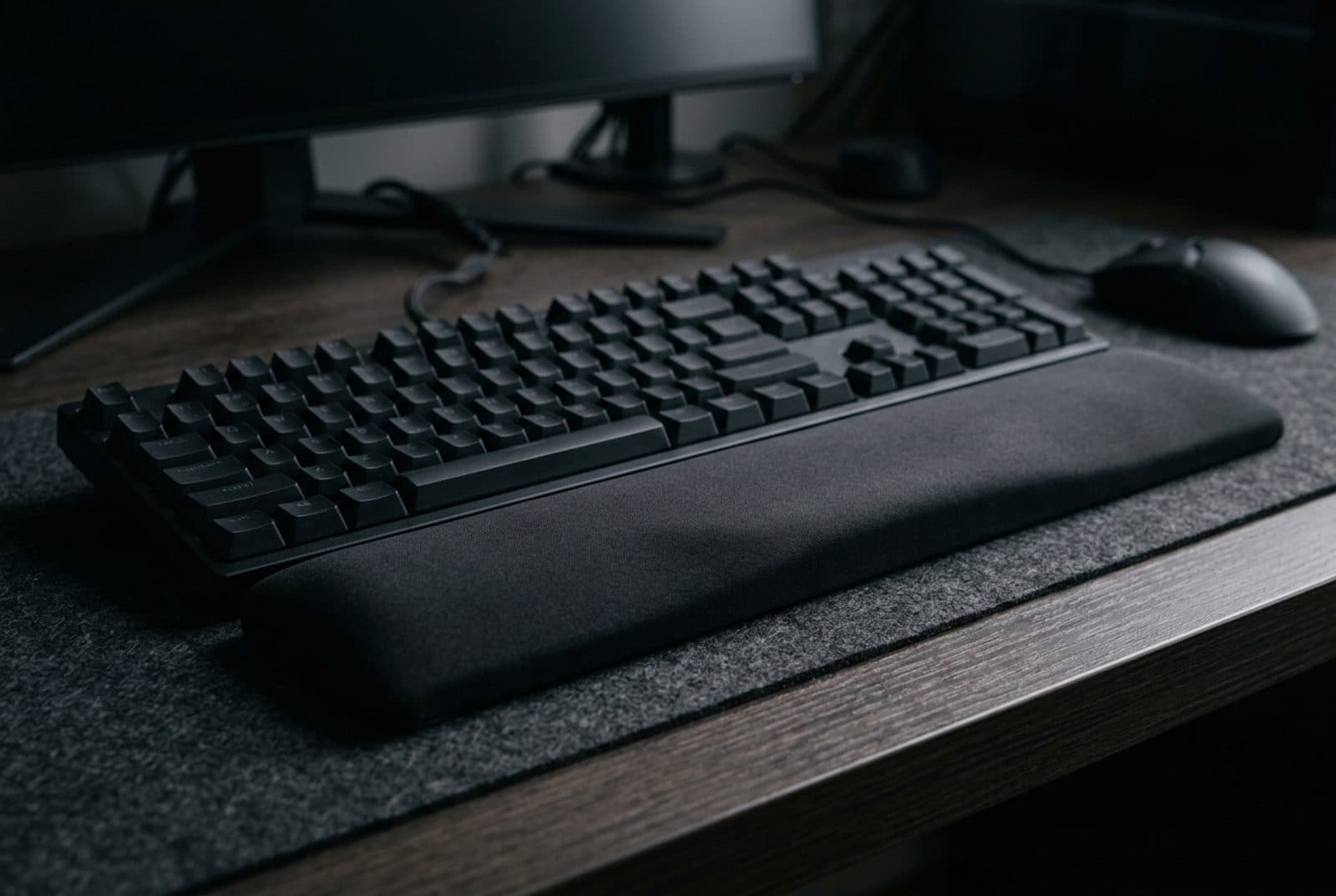 Razer Ergonomic Wrist Rest Pro, a plush full-width black wrist rest with a gently angled top surface, sitting in front of a full-size gaming keyboard