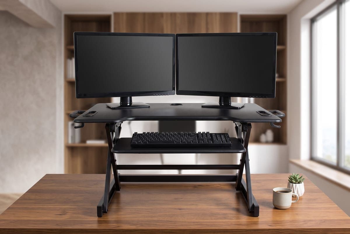 Rocelco DADR standing desk converter raised on a desk with two monitors on the top deck and a keyboard on the drop-down tray below