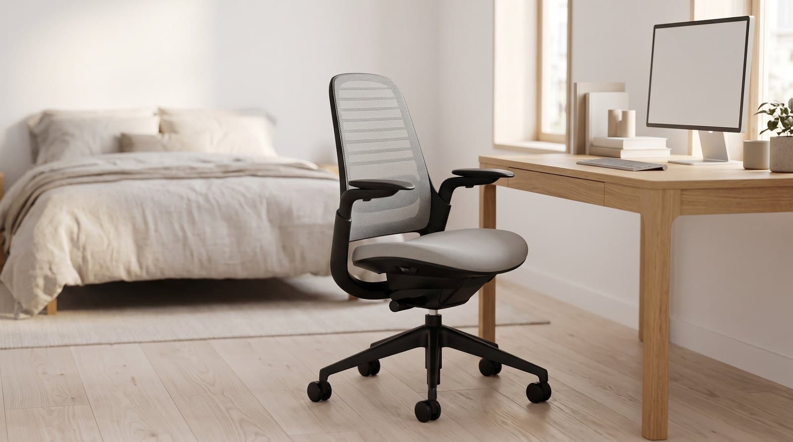 Steelcase Series 1 ergonomic task chair with a grey mesh back, black frame with integrated arm loops and a black five-star base, at a home-office desk